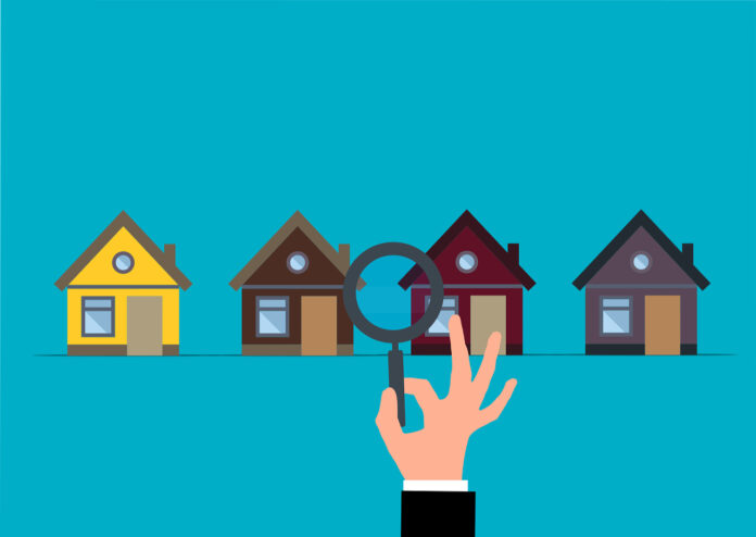 Immobiliensuche Symbolbild, Darstellung von vier Häusern und einer Lupe