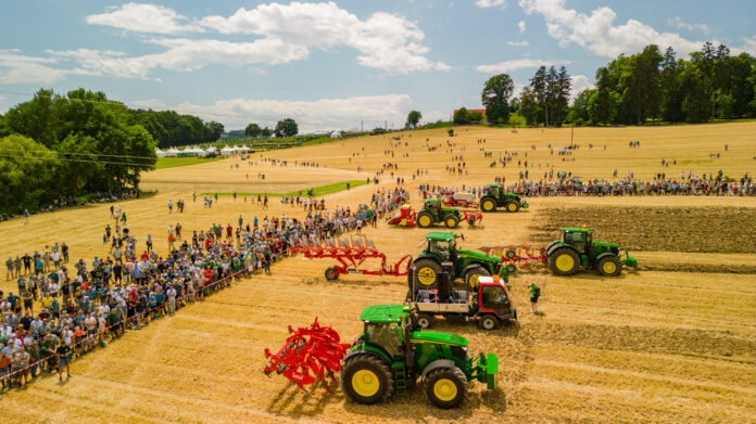 Traktoren auf einem Feld mit zahlreichen Besuchern