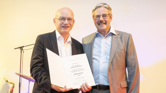 Generalanwalt Erwin Hameseder, Obmann der Raiffeisen-Holding NÖ-Wien, zeichnete Hannes Rauscher für seine Verdienste mit dem Ehrenzeichen in Gold aus.