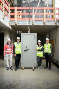 Die Panzertüre als Teil des 33,5 Tonnen schweren Baumaterials für den Tresorraum nahmen von links in Empfang: Bernhard Preiner (Projektleiter STRABAG), Reinhard Mayr (Vorstandsvorsitzender RLB Tirol), Sabine Sofia Haselwanter (Projektleiterin Das Raiqa) und Christof Splechtna (Vorstandsmitglied RLB Tirol).