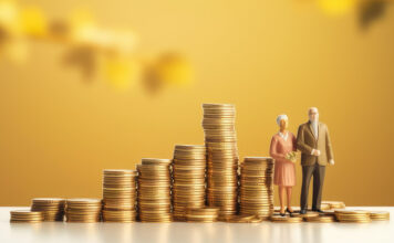 Symbolbild für altersvorsorge/Pensionssystem: gestapelte Münzen und Figuren eines Rentnerehepaars