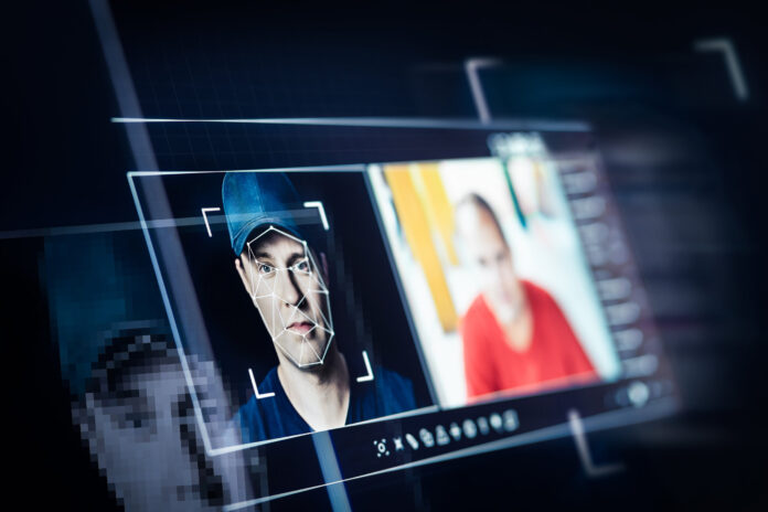 Symbolfoto, das Deepfake-Technologie mit zwei Gesichtern auf einem Bildschirm darstellen soll, als Symbolbild für Cybersecurity
