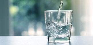 Wasser wird in ein Glas geleert