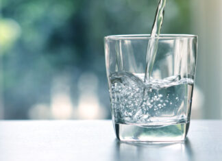 Wasser wird in ein Glas geleert