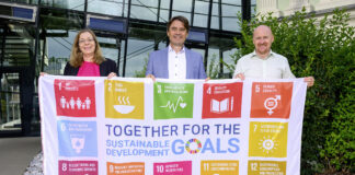 Petra Ibounig-Eixelsberger (Nachhaltigkeits­beauftragte), Gert Spanz und Wolfgang Saiwald (Projektmanager Nachhaltigkeit) hissen die SDG-Flagge.
