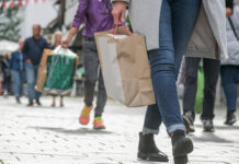 Menschen beim Shopping mit Einkaufstüten in der Innenstadt als Symbolbild für Handel