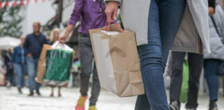 Menschen beim Shopping mit Einkaufstüten in der Innenstadt als Symbolbild für Handel
