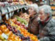 Elteres Ehepaar steht vor einem Gemüseregal im Supermarkt als Symbolbild für Pension und betriebliche Vorsorge