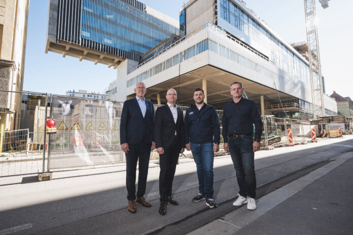 Reinhard Mayr und Christof Splechtna mit Martin Rauchenbacher und Ernst Scherer von der Zimmerei Scherer vor der Baustelle des Raiqa.