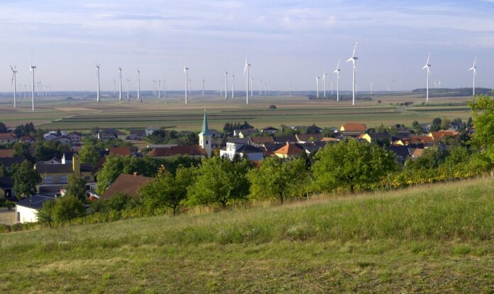 Burgenländische Gwmeinde mit Windrädern am Horizont als Symbolbild für Burgenland