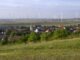 Burgenländische Gwmeinde mit Windrädern am Horizont als Symbolbild für Burgenland