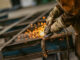 Heavy industry worker grinds steel with an angle grinder,sparks flying,close up. Symbolbild für Industrie und Wirtschaft in Osteuropa