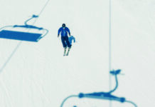 Einzelner Skifahrer auf der Piste, als Symbolbild für Skifahren, Wintersport, Tourismus