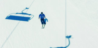 Einzelner Skifahrer auf der Piste, als Symbolbild für Skifahren, Wintersport, Tourismus