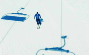 Einzelner Skifahrer auf der Piste, als Symbolbild für Skifahren, Wintersport, Tourismus