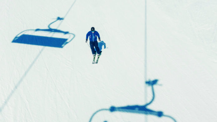 Einzelner Skifahrer auf der Piste, als Symbolbild für Skifahren, Wintersport, Tourismus