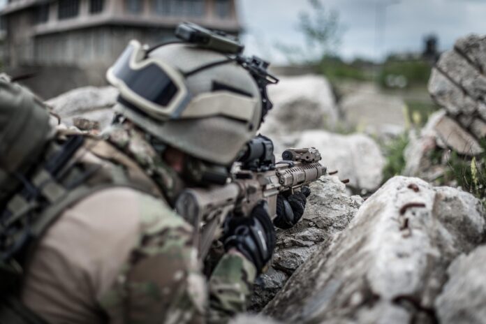 Soldat von hinten mit Helm und Gewehr als Symbolbild für Krieg