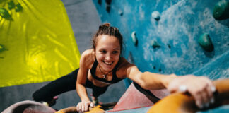 Symbolfoto, Frau auf einer Kletterwand