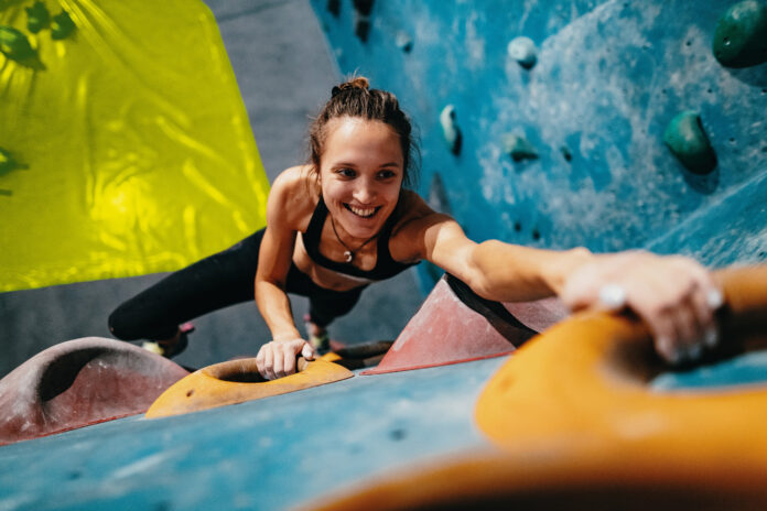 Symbolfoto, Frau auf einer Kletterwand