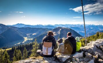 Eine Familie bei einer Wanderung blicken auf das Bergpanorama, als Symbolbild für Patchworkfamilie