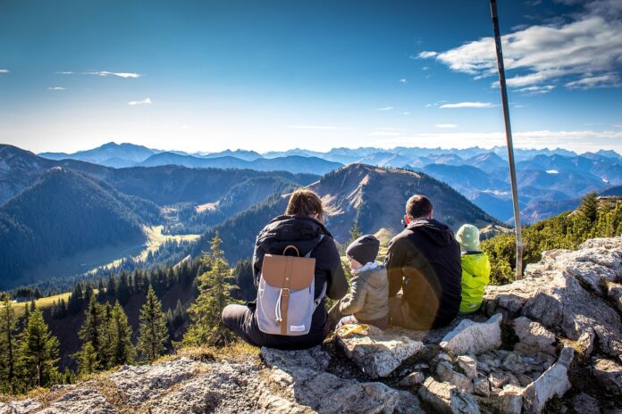 Eine Familie bei einer Wanderung blicken auf das Bergpanorama, als Symbolbild für Patchworkfamilie