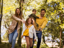Glückliche Familie. Eltern verbringen Zeit mit ihren Kindern draußen im Wald.