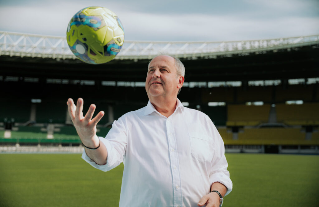 Josef Pröll wirft einen Fußball im Stadion