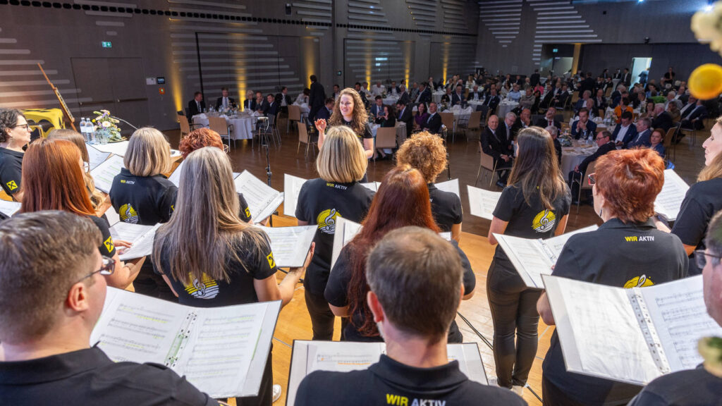Chor singt auf der Bühne bei der Hauptversammlung von Raiffeisen Steiermark