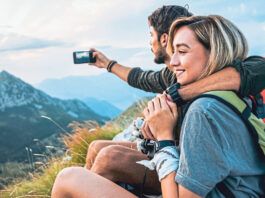 happy young couple enjoying the hike together and taking pictures
