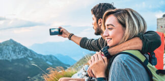 happy young couple enjoying the hike together and taking pictures