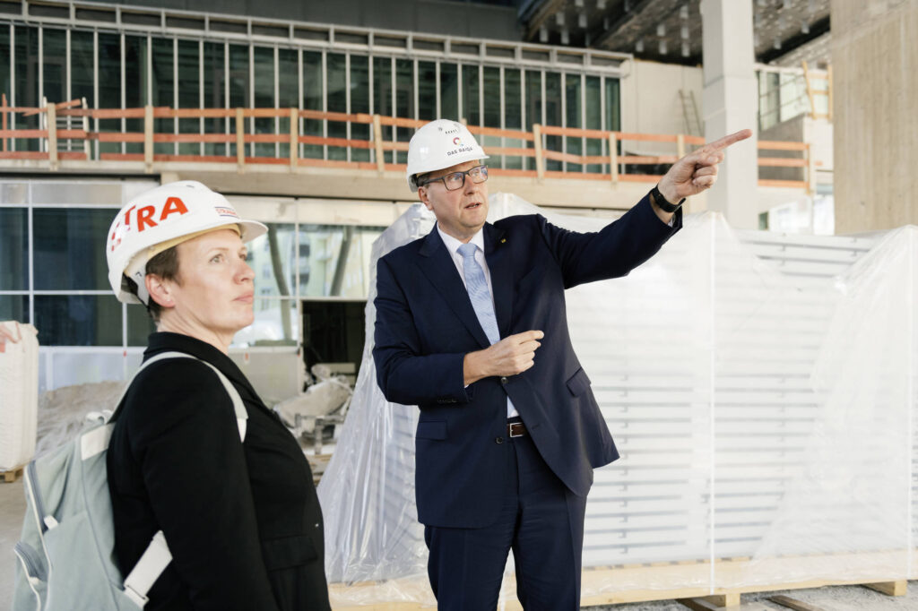 RLB-Tirol-Vorstand Thomas Wass zeigt Elisabeth Hell die Raiqa-Baustelle