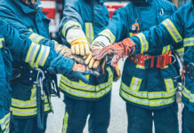 Feuerwehrmänner, die ihre Hände in der Mitte aufeinanderlegen als Symbolbild für den Raiffeisen Sozialbericht