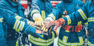 Feuerwehrmänner, die ihre Hände in der Mitte aufeinanderlegen als Symbolbild für den Raiffeisen Sozialbericht