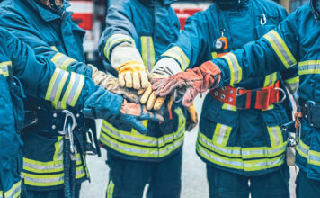 Feuerwehrmänner, die ihre Hände in der Mitte aufeinanderlegen als Symbolbild für den Raiffeisen Sozialbericht