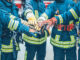 Feuerwehrmänner, die ihre Hände in der Mitte aufeinanderlegen als Symbolbild für den Raiffeisen Sozialbericht