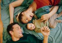 Vater, Mutter und babay liegen in einem Bett