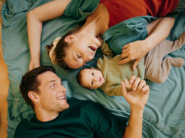 Vater, Mutter und babay liegen in einem Bett