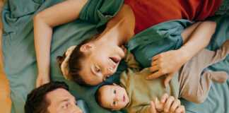 Vater, Mutter und babay liegen in einem Bett