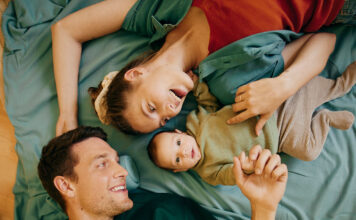 Vater, Mutter und babay liegen in einem Bett