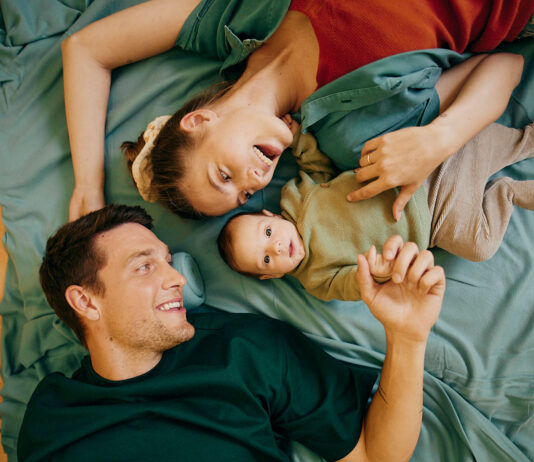 Vater, Mutter und babay liegen in einem Bett