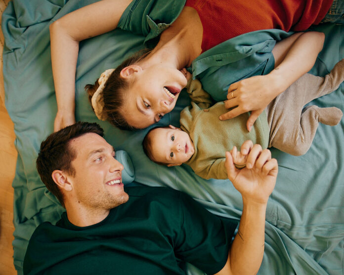 Vater, Mutter und babay liegen in einem Bett