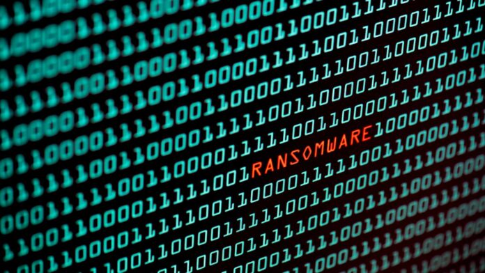 Symbolbild Cybercrime: Bildschirm mit Binärcode und dem Wort 