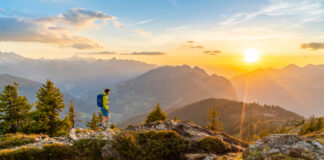 Wanderer in der Abendsonne vor Bergpanorama
