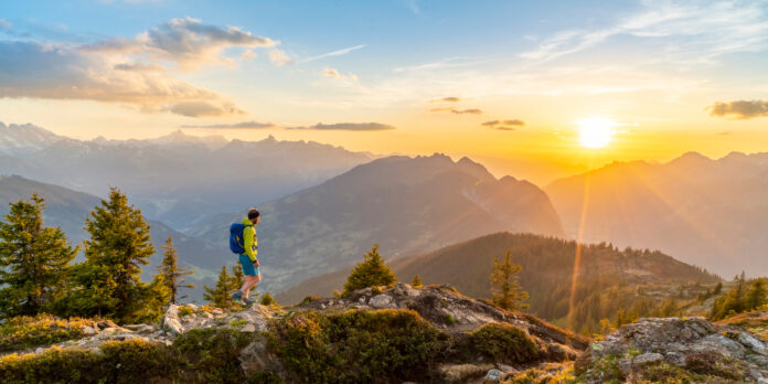 Wanderer in der Abendsonne vor Bergpanorama
