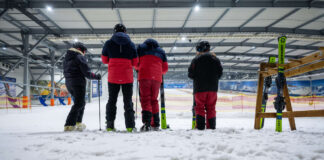 Skifahrer:innen in einer Skihalle