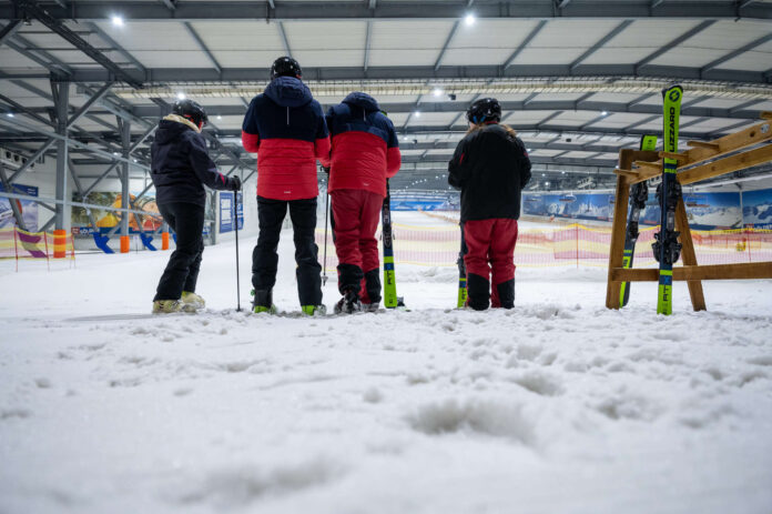 Skifahrer:innen in einer Skihalle