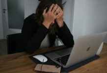 Frau vor Laptop hält den Kopf in ihren Händen, Symbolbild für Anlagebetrug