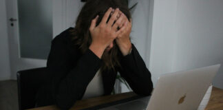 Frau vor Laptop hält den Kopf in ihren Händen, Symbolbild für Anlagebetrug