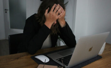 Frau vor Laptop hält den Kopf in ihren Händen, Symbolbild für Anlagebetrug