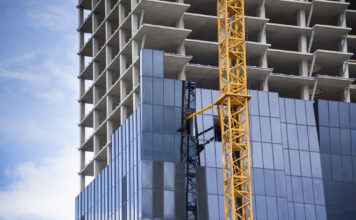 Ein im Bau befindliches Hochhaus mit gekben Kran davor